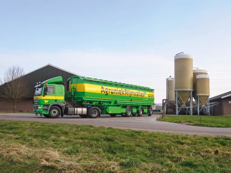 AgruniekRijnvallei bulkwagen met op de achtergrond een aantal mooie, schone voersilo's